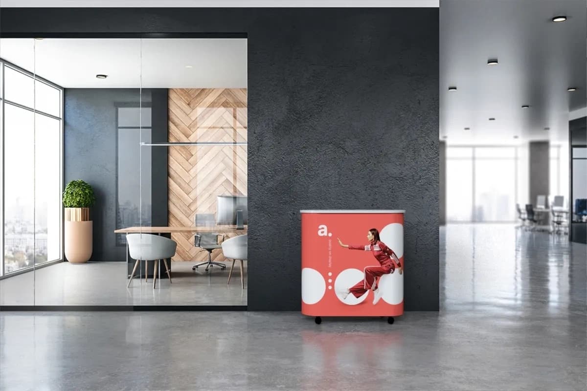 Un comptoir d'accueil publicitaire moderne et épuré avec un logo visible, idéal pour un événement ou un espace d'exposition