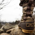 Bottes sur un rocher avec un paysage de collines nues