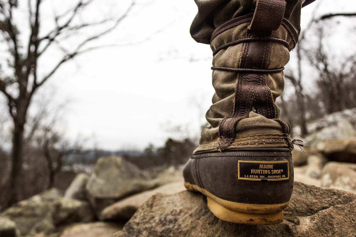 Bottes sur un rocher avec un paysage de collines nues