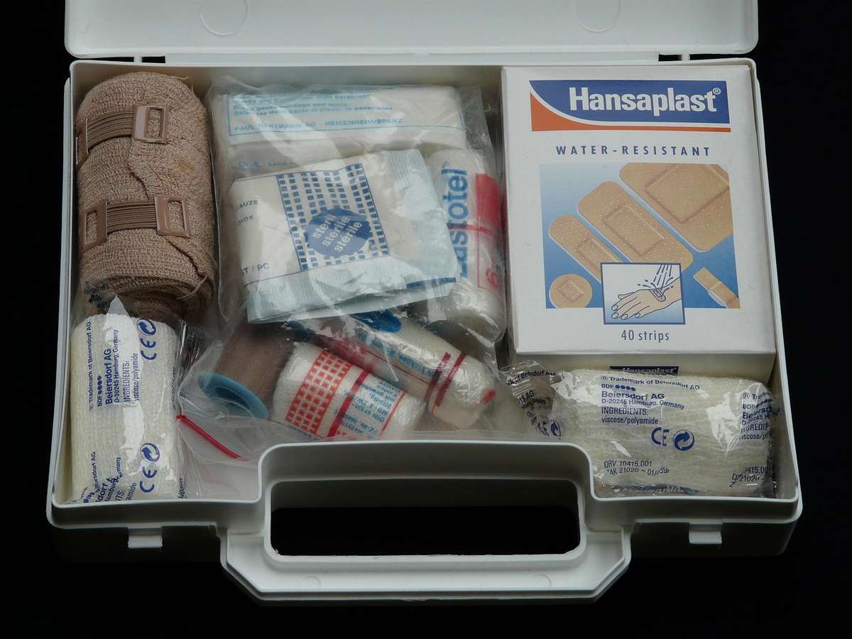 Une boîte à outils médicale contenant pansements, bandages, ciseaux et désinfectant