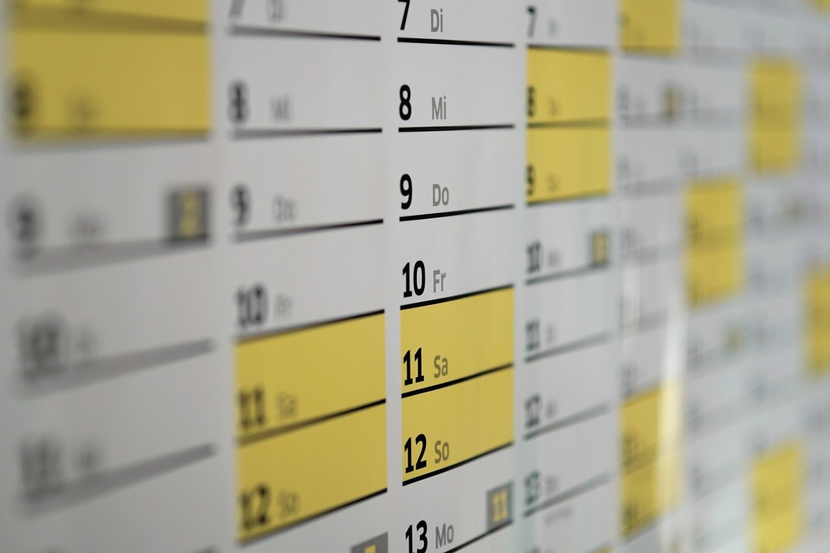 Calendrier affiché au mur, dates et jours en surbrillance jaune