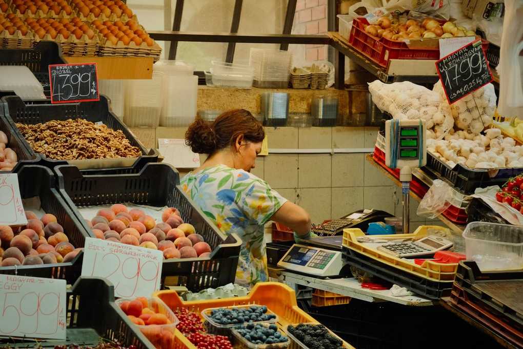 Vendeuse dans un marché, pesant des fruits et légumes