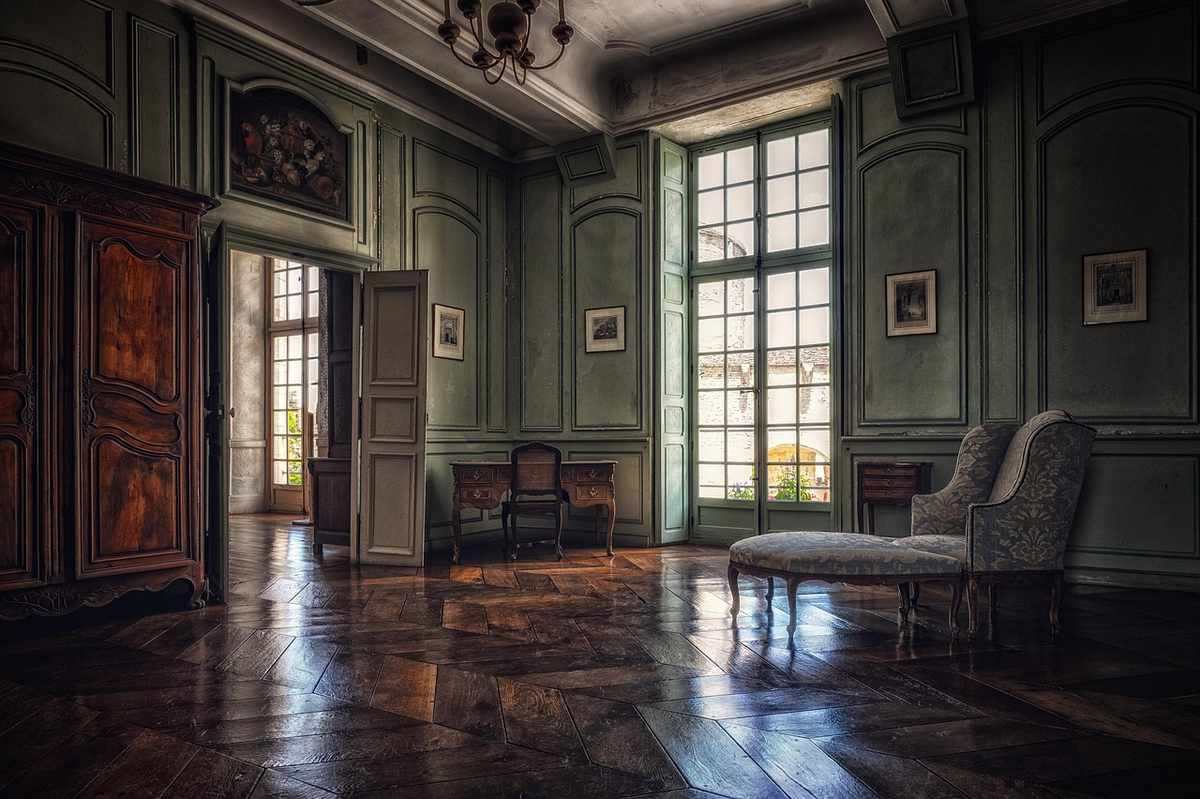 Intérieur classique montrant un large parquet en bois ancien brillant dans une pièce aux boiseries vertes Intérieur classique montrant un large parquet en bois ancien brillant dans une pièce aux boiseries vertes