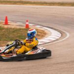 Pilote de kart en virage sur circuit, cônes de sécurité orange