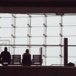 Silhouettes d voyageurs devant une grande vitre, chaises et bagages